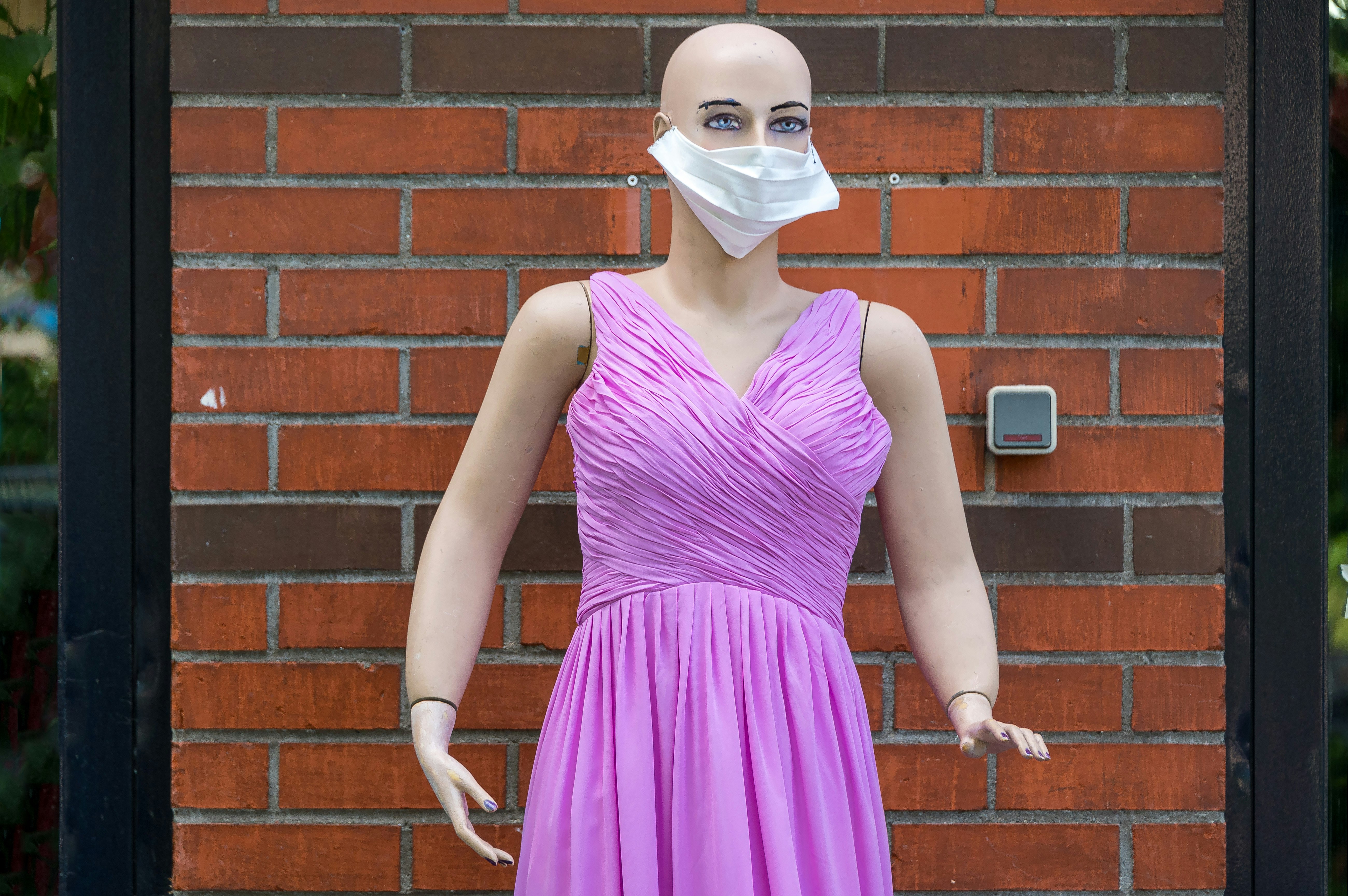 woman in purple sleeveless dress wearing white face mask